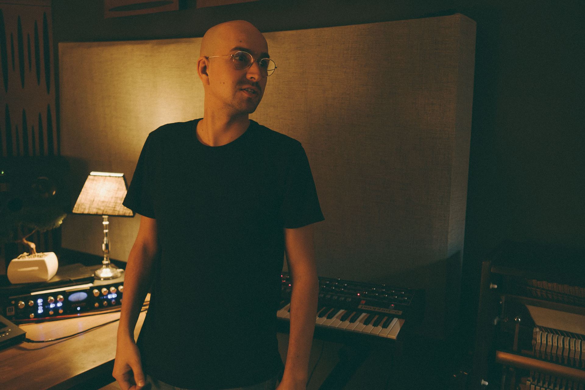 Chriskey steht nachdenklich vor einem Klavier im Studio.
